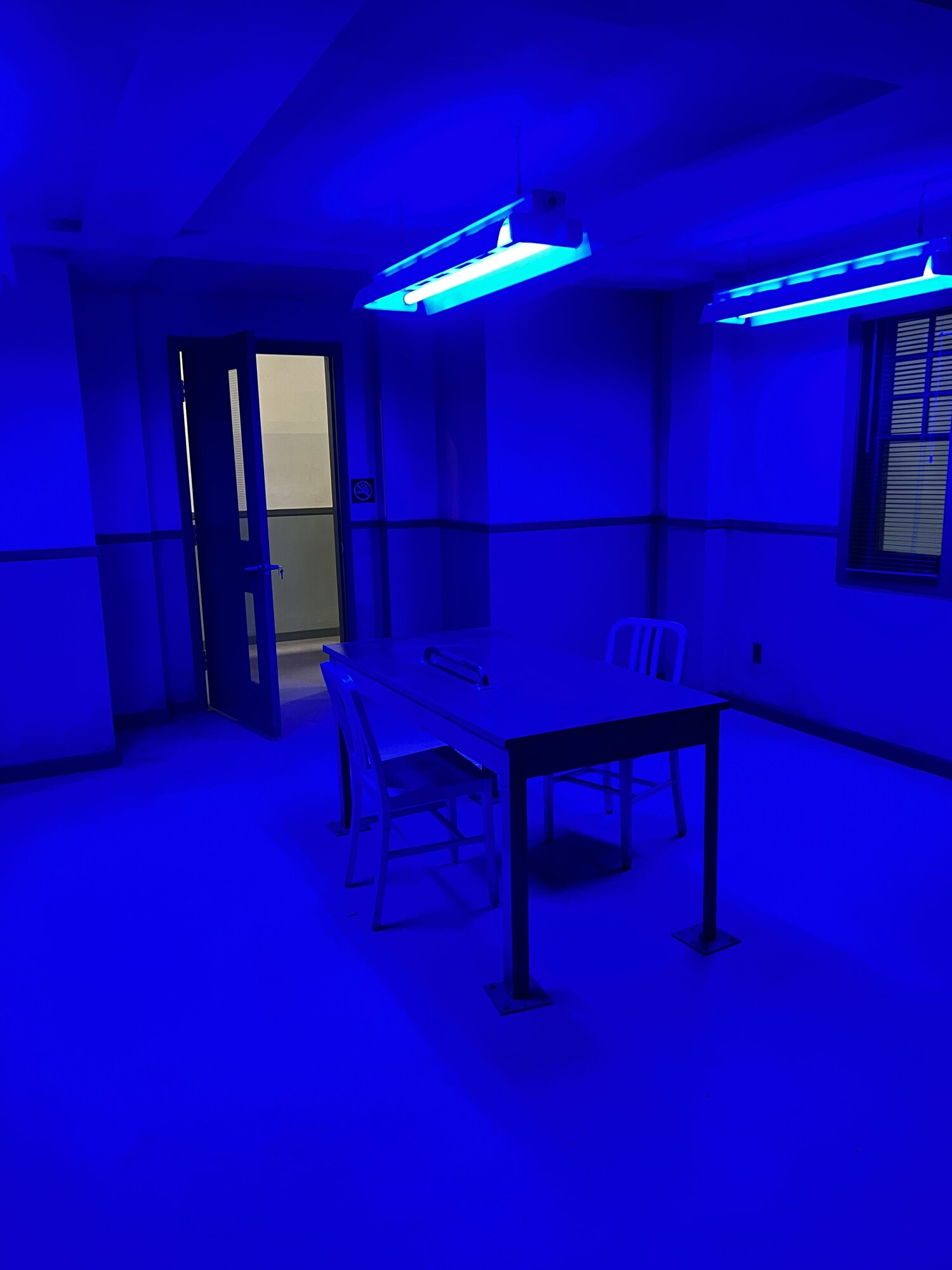Set room illuminated with saturated blue practical lighting