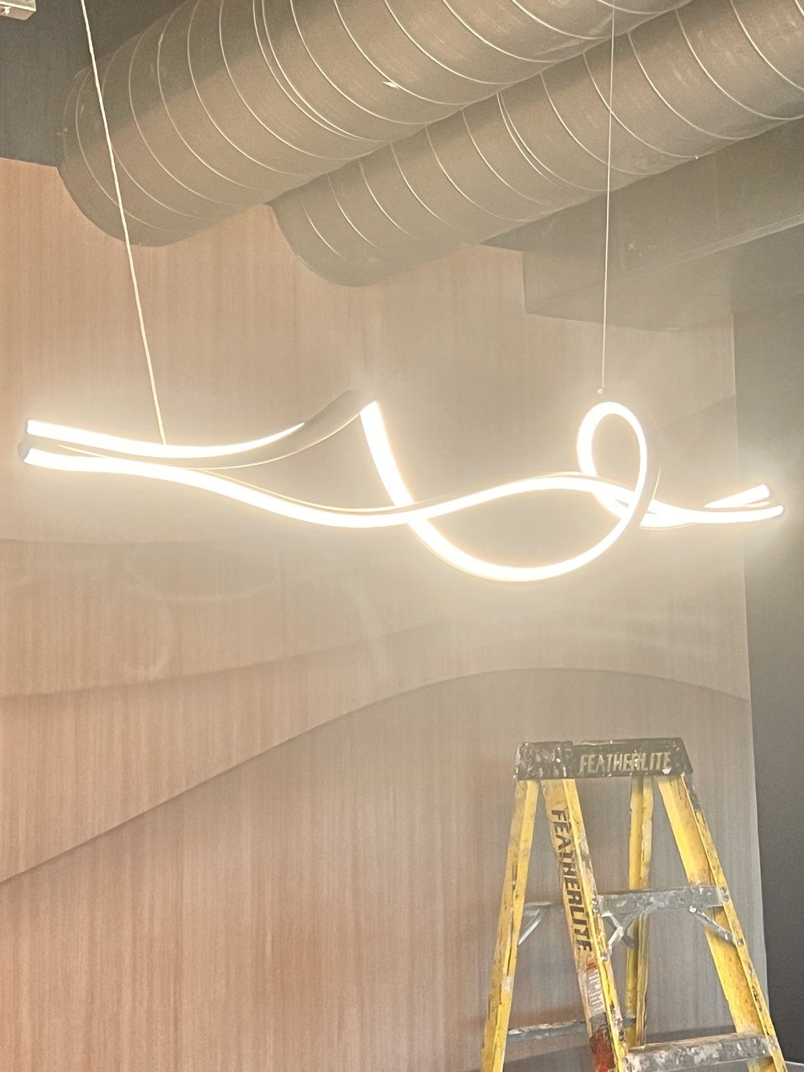 Sculptural suspended linear light feature in a residential interior