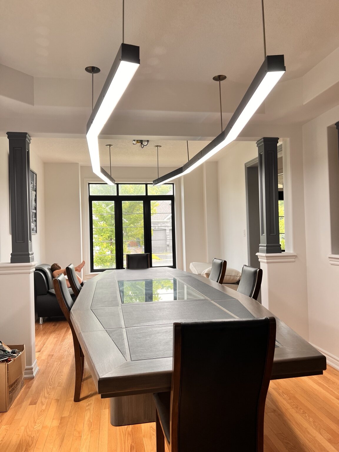 Residential dining room with sculptural suspended linear lighting